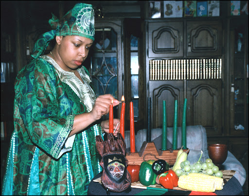 woman lighting Kwanzaa candles