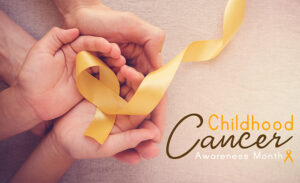 Yellow ribbon, representing childhood cancer awareness, in a child's and adult's cupped hands