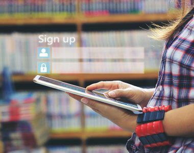 Woman with tablet in library, "Sign up" fields hovering in air