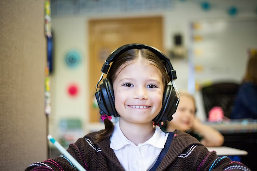Young student in classroom with headphones