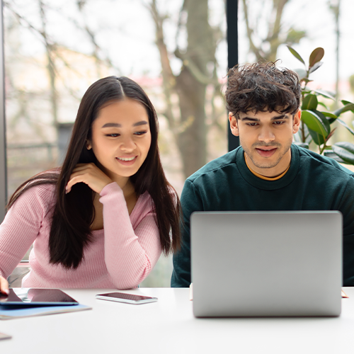 Teens looking at laptop