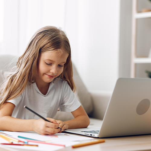 Child doing homework in front of laptop
