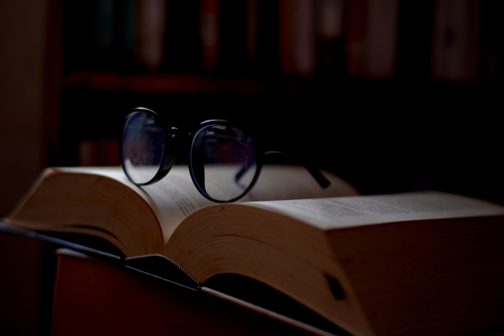 Open book with glasses on top